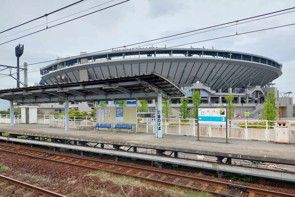 JR市坪駅と、その向こうに見える坊っちゃんスタジアム